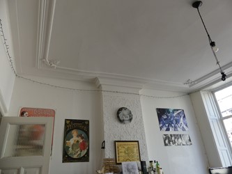 <p>Overzicht van de voorkamer op de eerste verdieping. De schouwboezem, het stucplafond en de raambetimmering uit het midden van de 19e eeuw is nog aanwezig.</p>
